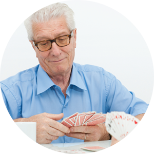 An older man with glasses playing cards